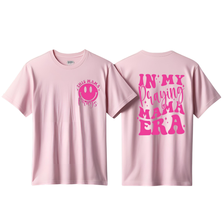 Two pink colored women's t-shirts with text on them. One displays 'In My Praying' and the other shows 'Mama Era'.