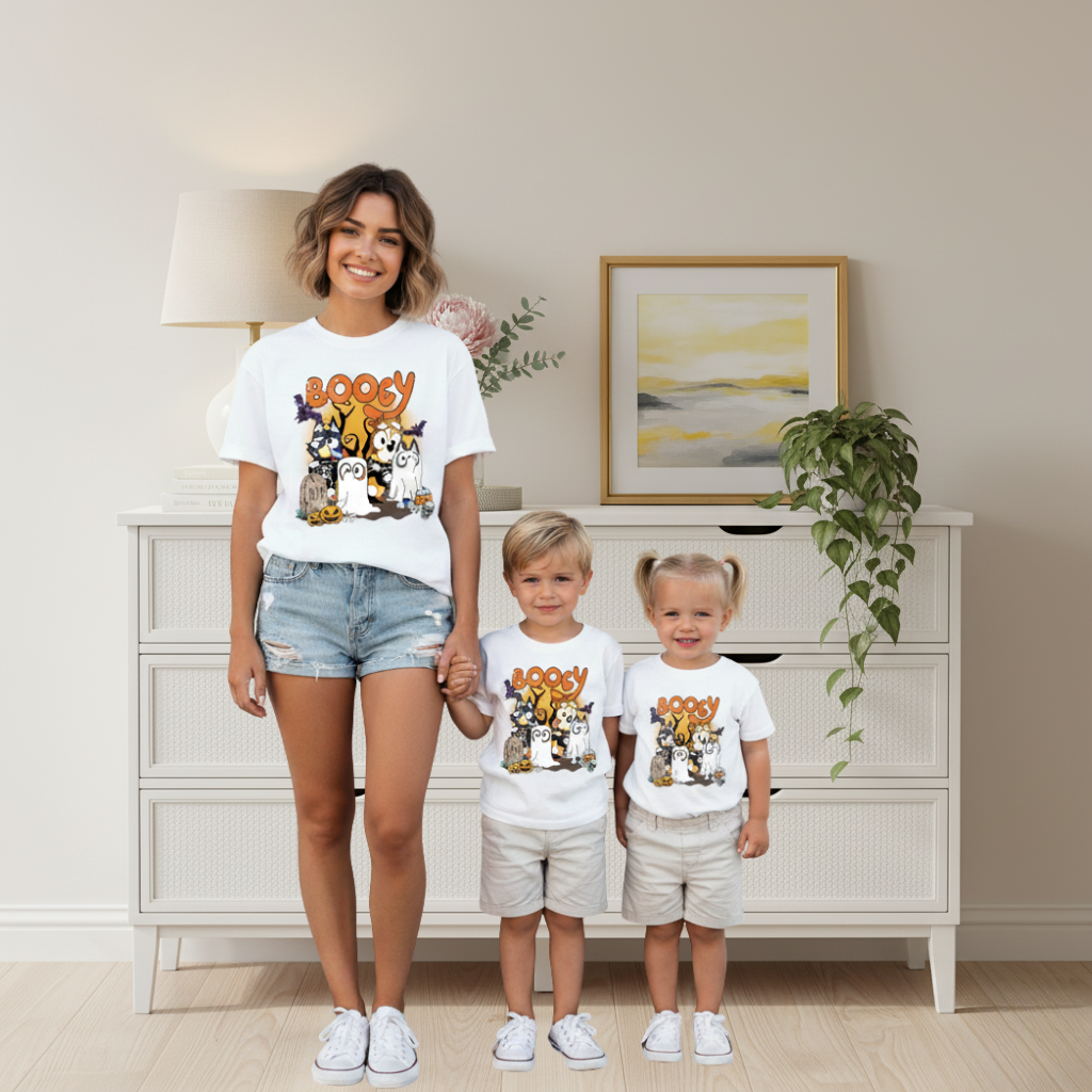 Woman and two children wearing matching t-shirts in a room with a dresser and decor.