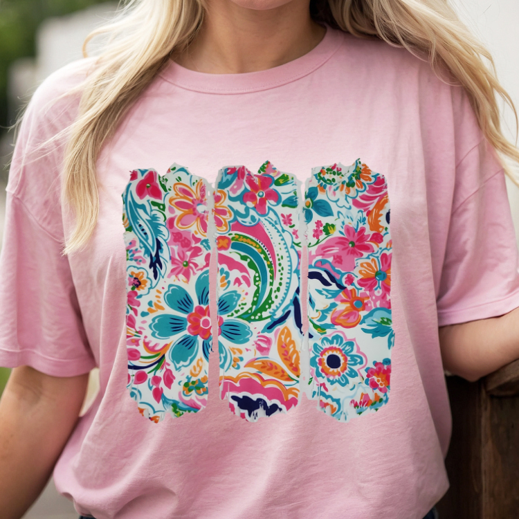 Person wearing a pink t-shirt with colorful floral design