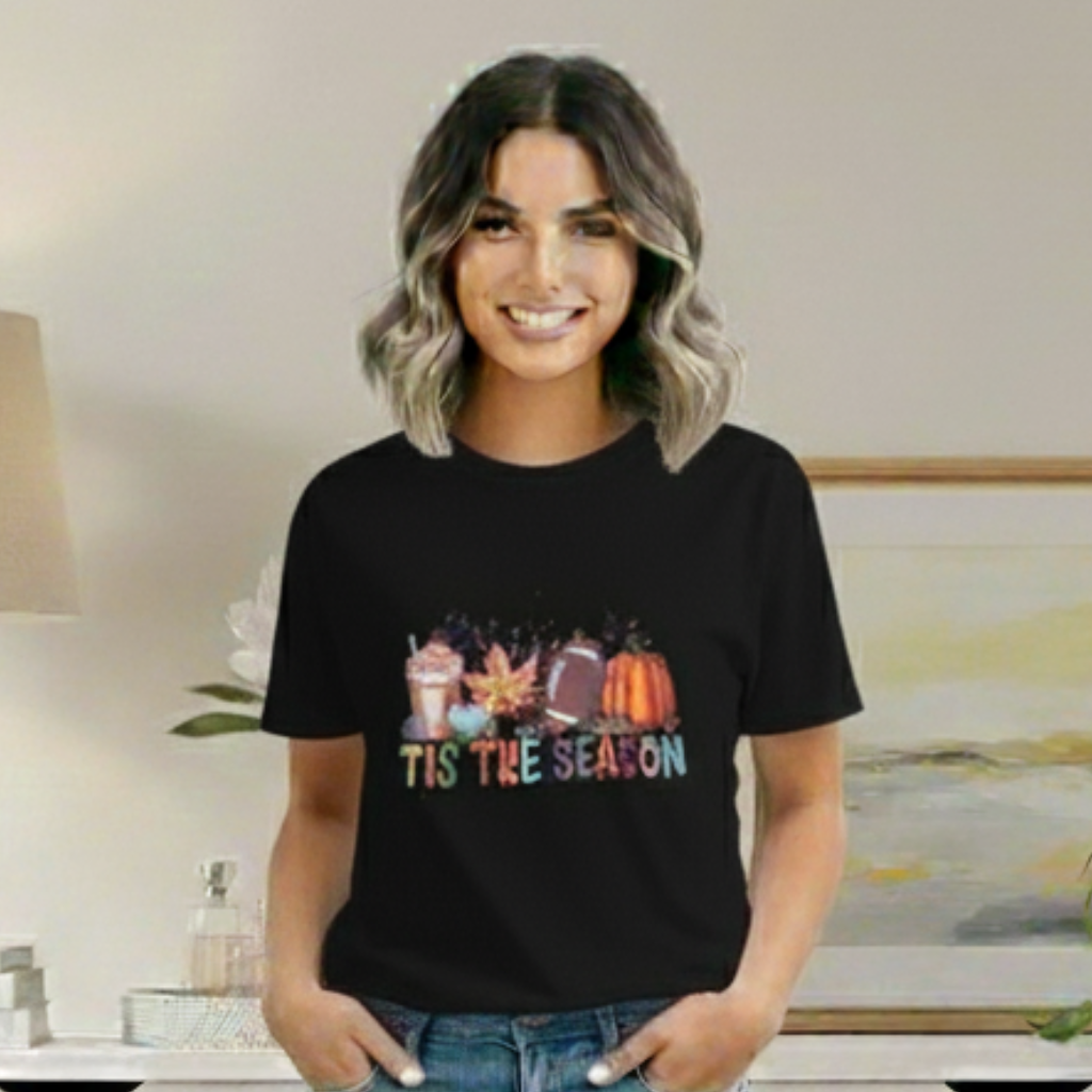 Woman wearing a black t-shirt with 'Tis the Season' design in a casual setting.